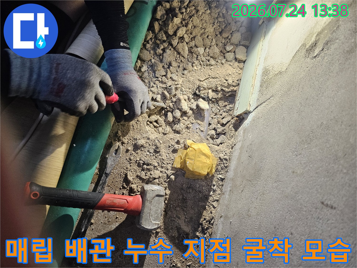 바닥을 파내어 드러난 흙과 자갈 그리고 작업 도구들이 놓여 있는 현장 사진
