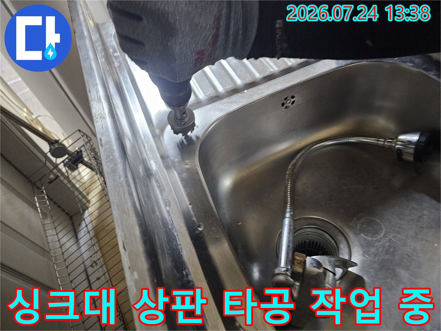 작업자가-전동-홀쏘-장비를-이용해-스테인리스-싱크대-상판에-구멍을-뚫고-있는-모습