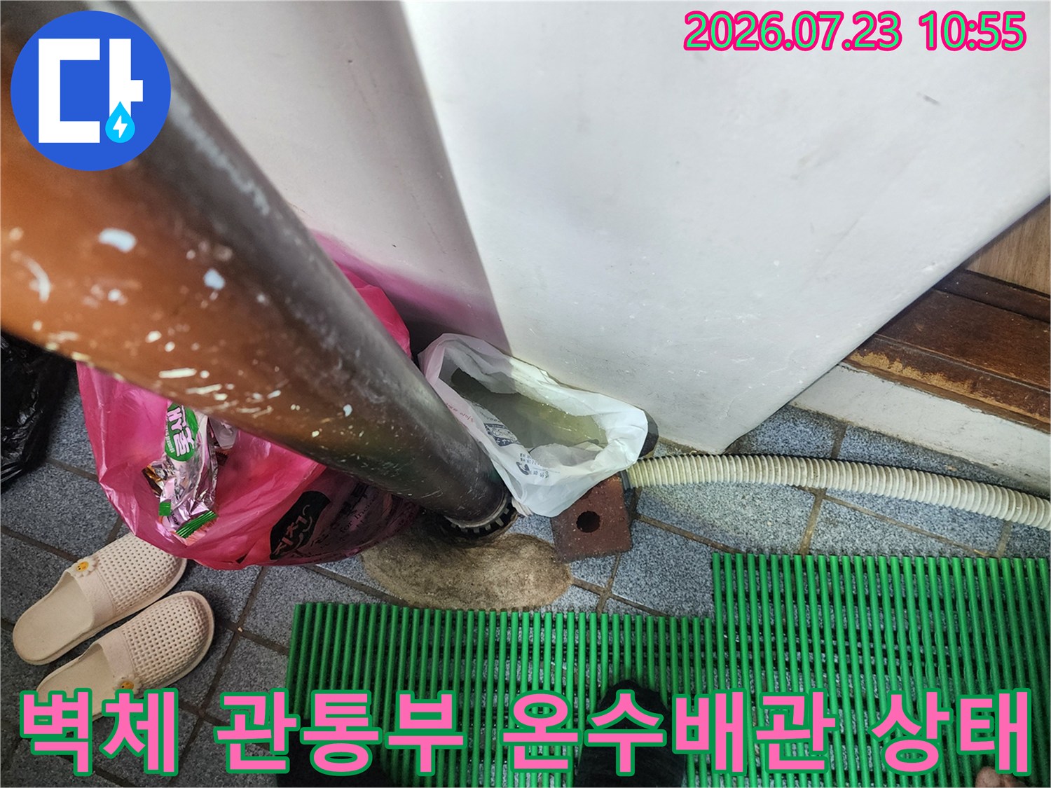 벽을 통과하여 바닥으로 이어지는-금속제 온수 배관의 연결 부위 모습