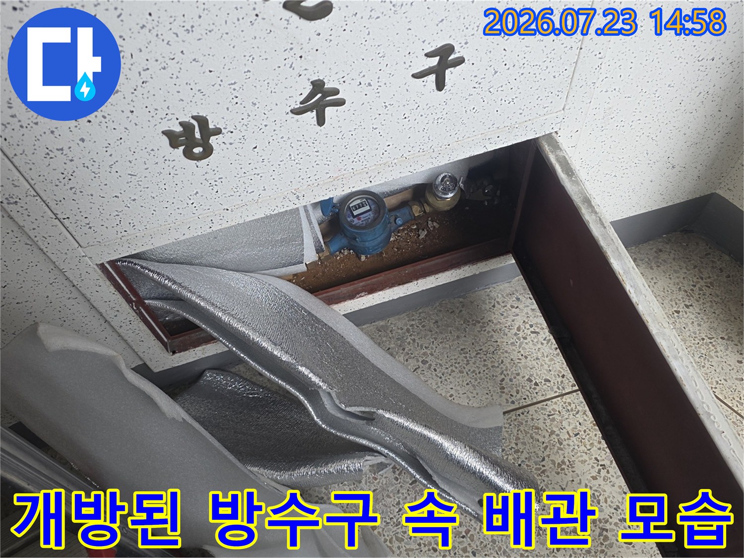 벽면-방수구-내부에-설치된-은색-배관-보온재와-파란색-밸브의-근접-사진