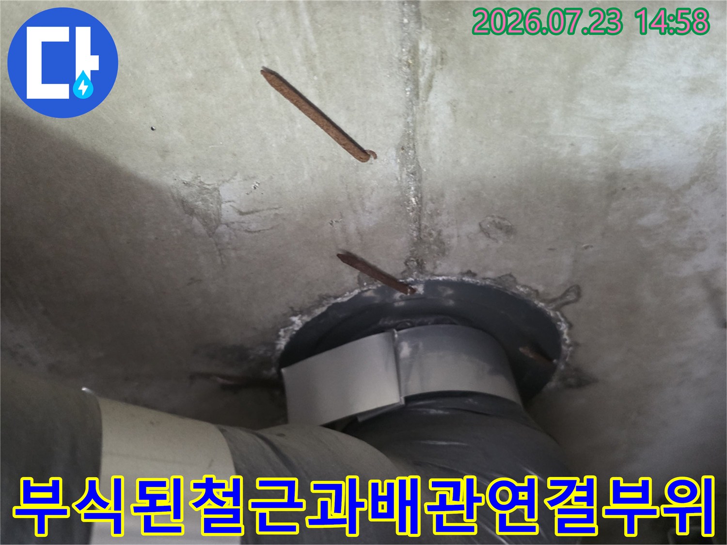 콘크리트 천장 슬라브를 관통하는 배관 주변의 부식된 철근과 균열 모습