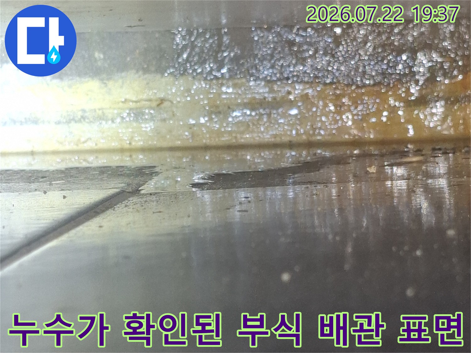 오랜 사용으로 인해 부식이 진행되어 물이 새어 나오는 금속 배관 사진