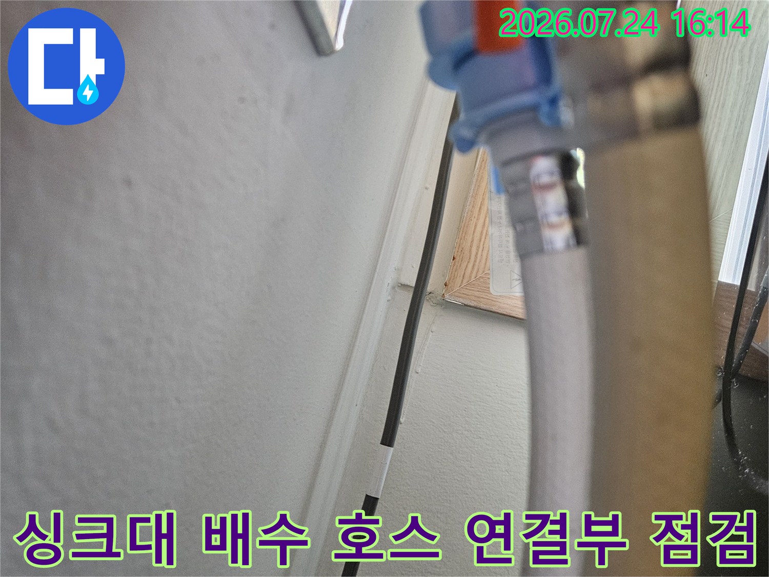 오렌지색 보호재로 감싸진 싱크대 하부 배수관 연결 부위 확인
