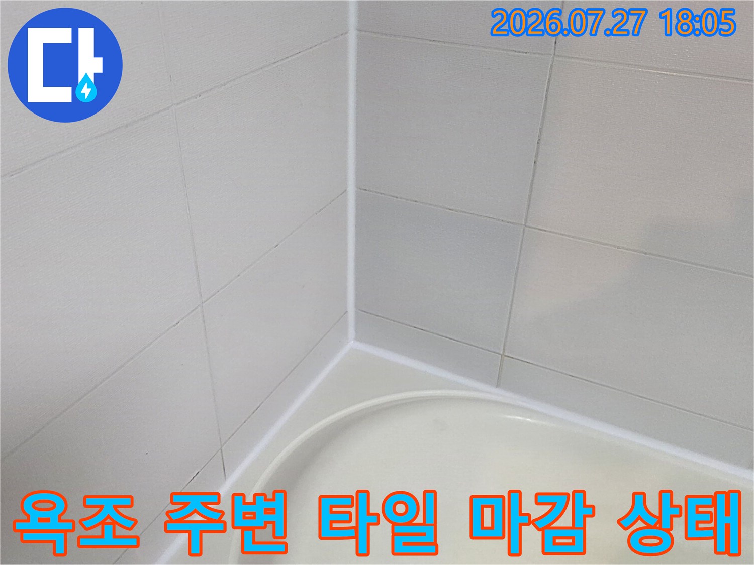 욕실 내부의 하얀색 욕조와 수직으로 세워진 벽면 타일의 접합 라인 사진