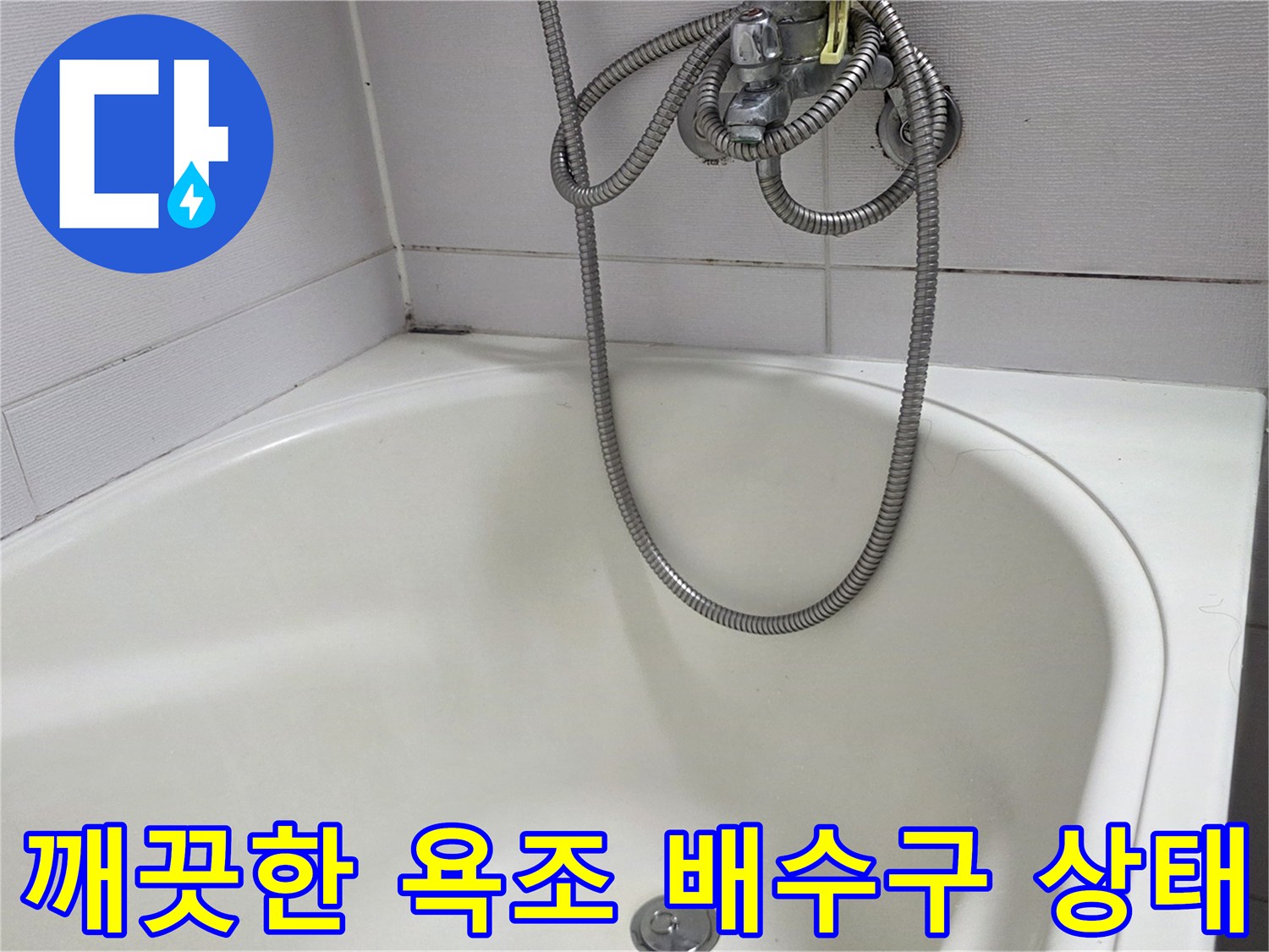 욕조 바닥의 은색 배수구와 샤워 호스 연결부입니다.