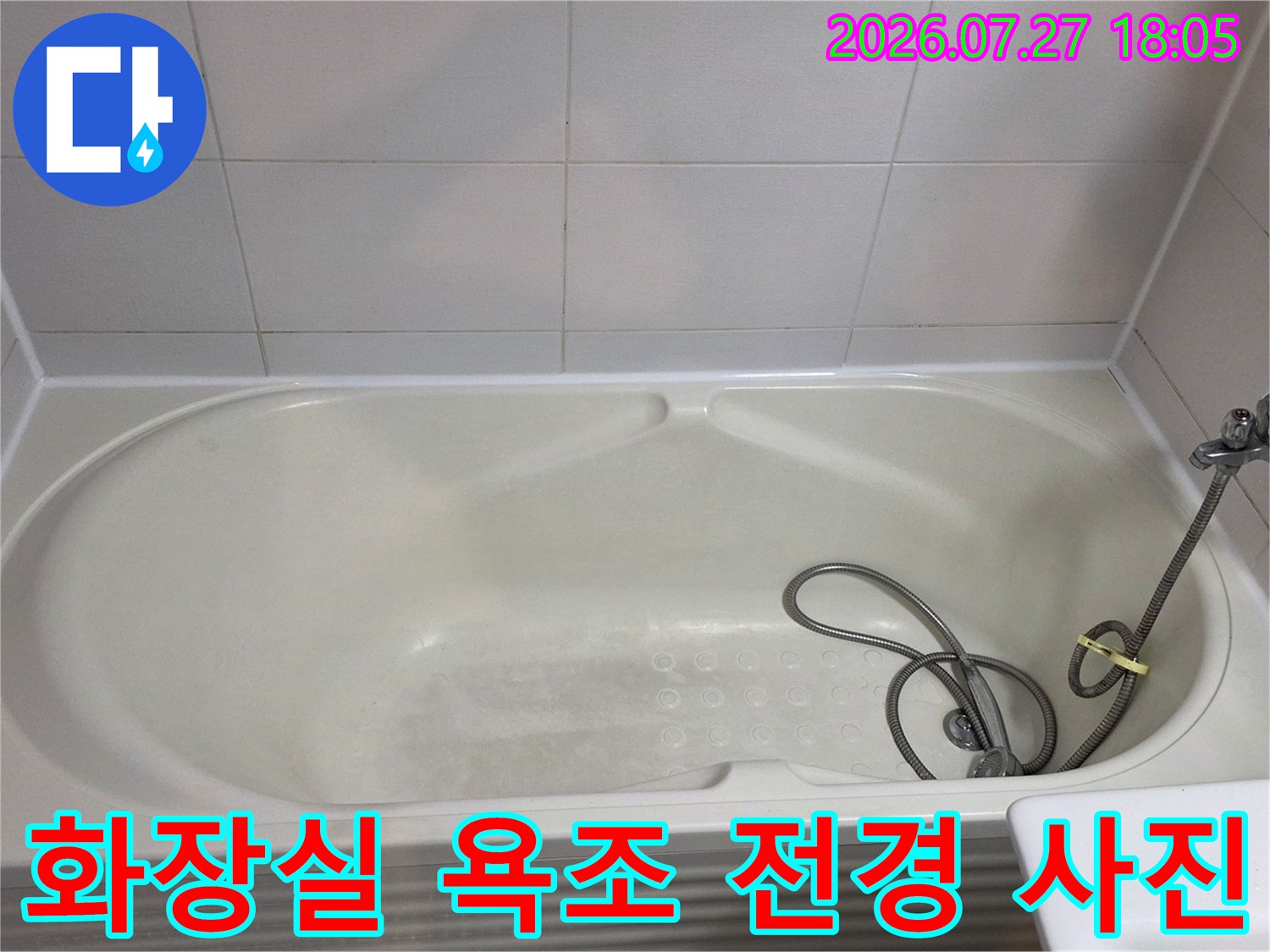 욕조 옆으로 샤워기가 설치되어 있고 벽면 타일이 배치된 화장실 모습
