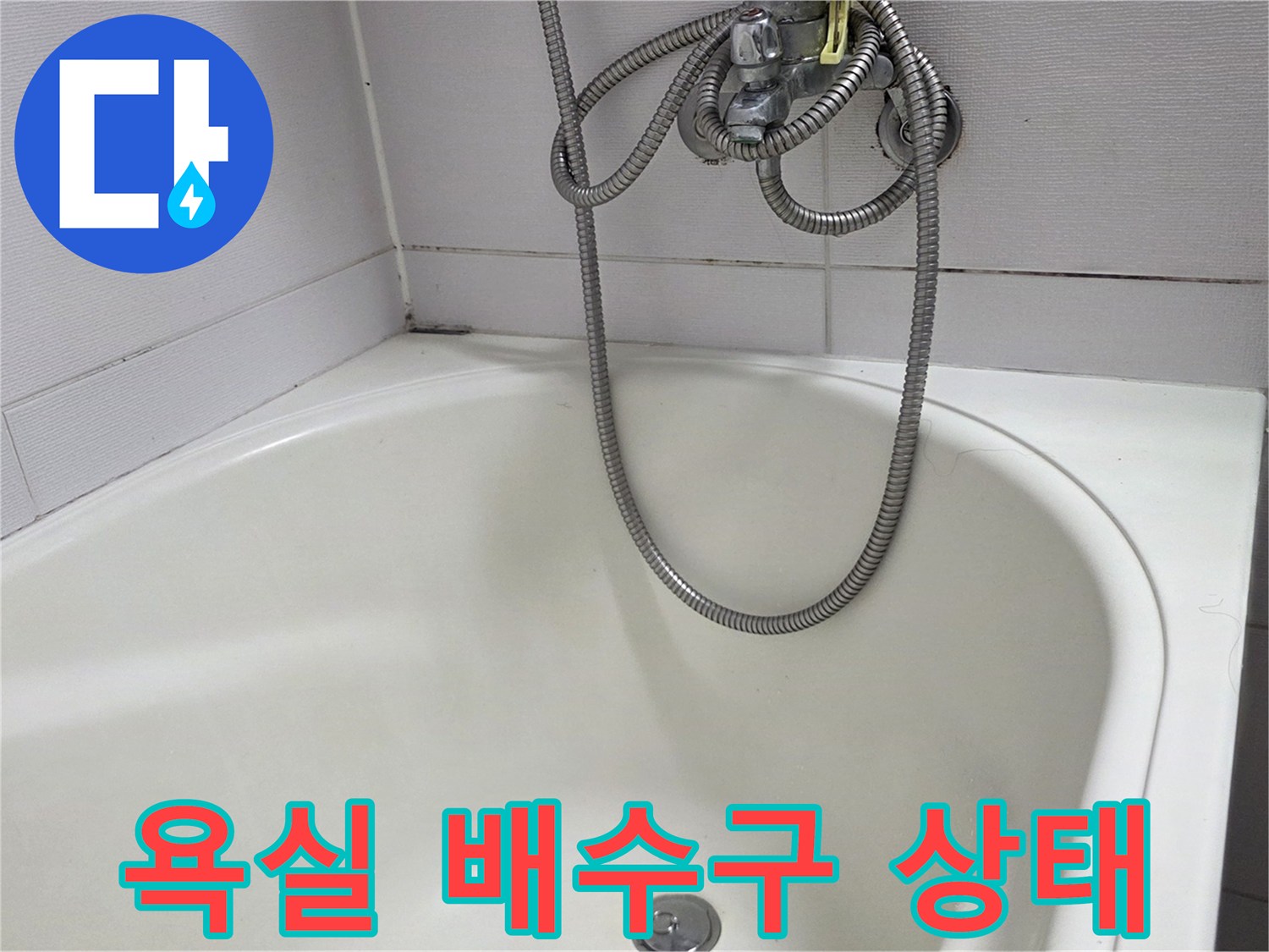 하얀색 욕조 내부의 배수구와 샤워기 호스 모습