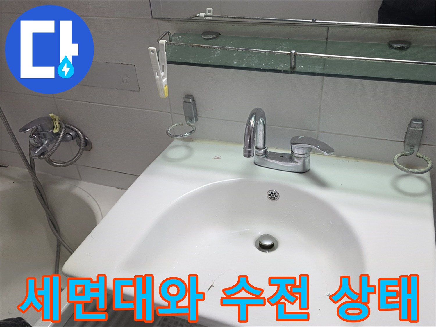 화이트 세면대에 설치된 크롬 수전과 욕실 벽면 모습