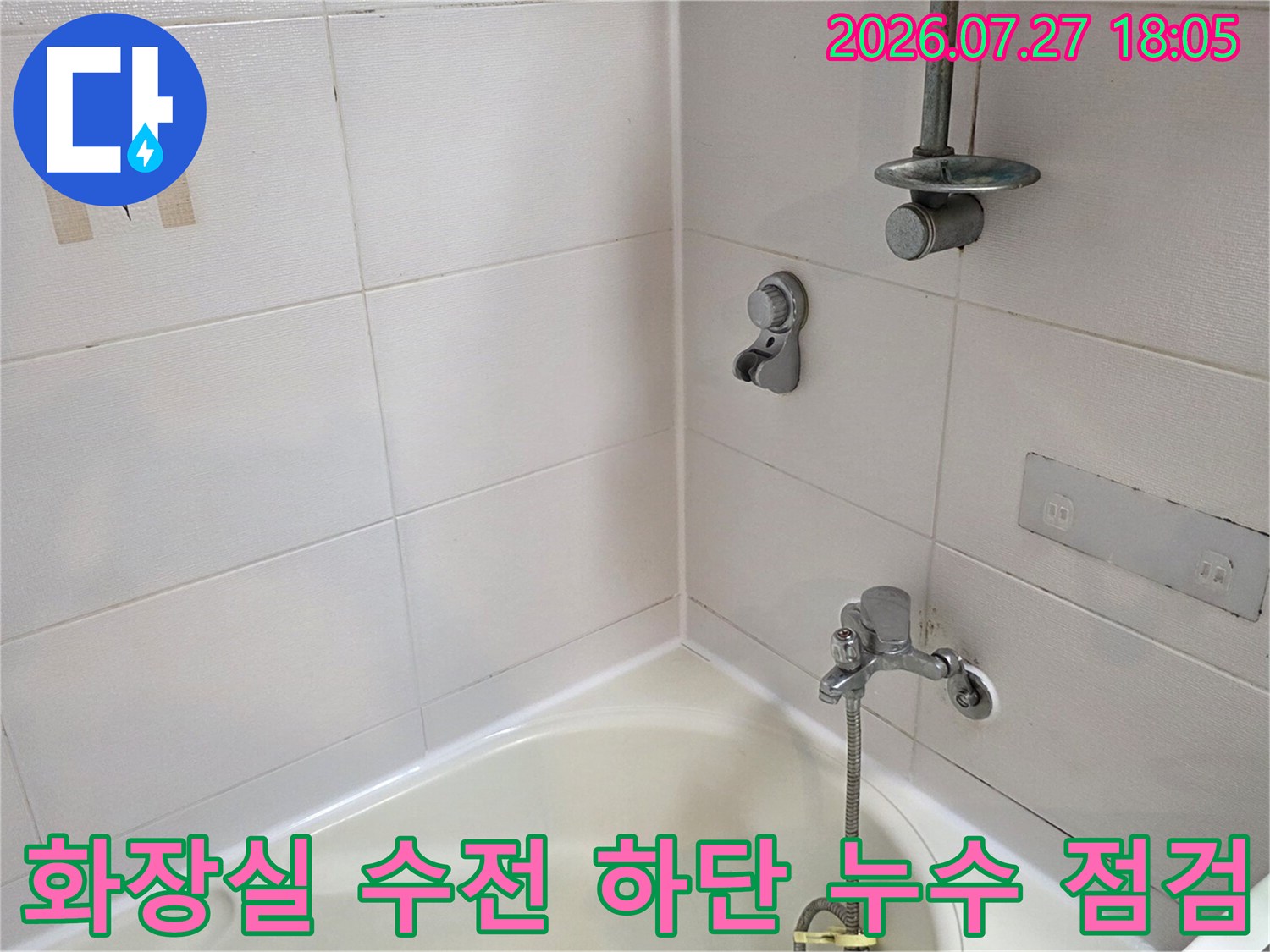 흰색 욕조와 타일 벽면이 만나는 모서리 부분과 샤워 수전의 모습