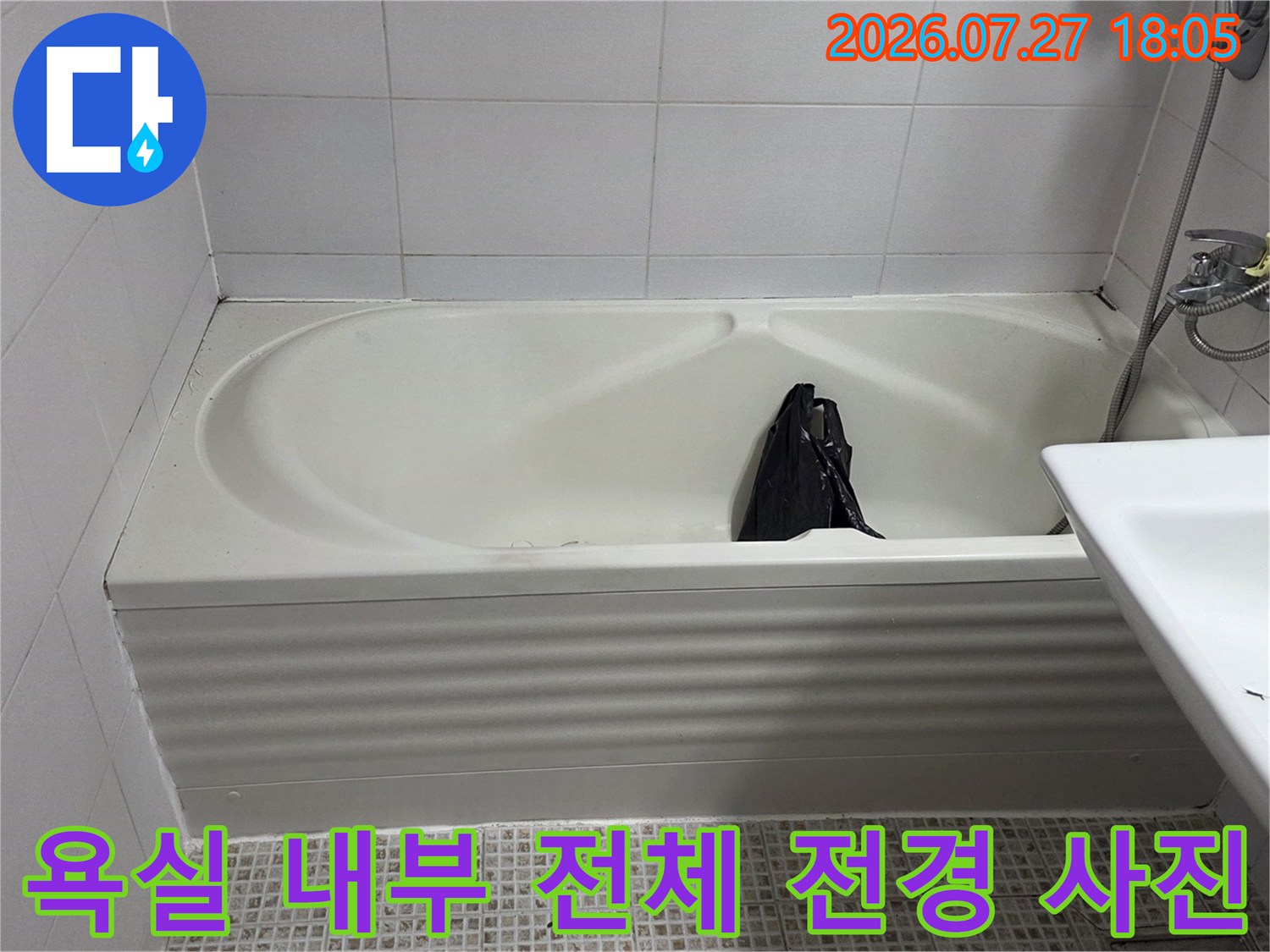 흰색 타일로 마감된 욕실의 욕조와 세면대-전체적인 누수 점검을 위한 현장 모습