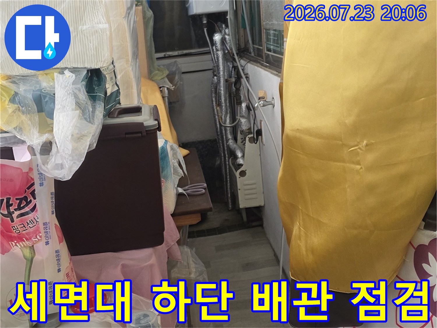 세면대 아래의 복잡한 배관 구조를 파악하고 누수 원인을 분석하는 모습