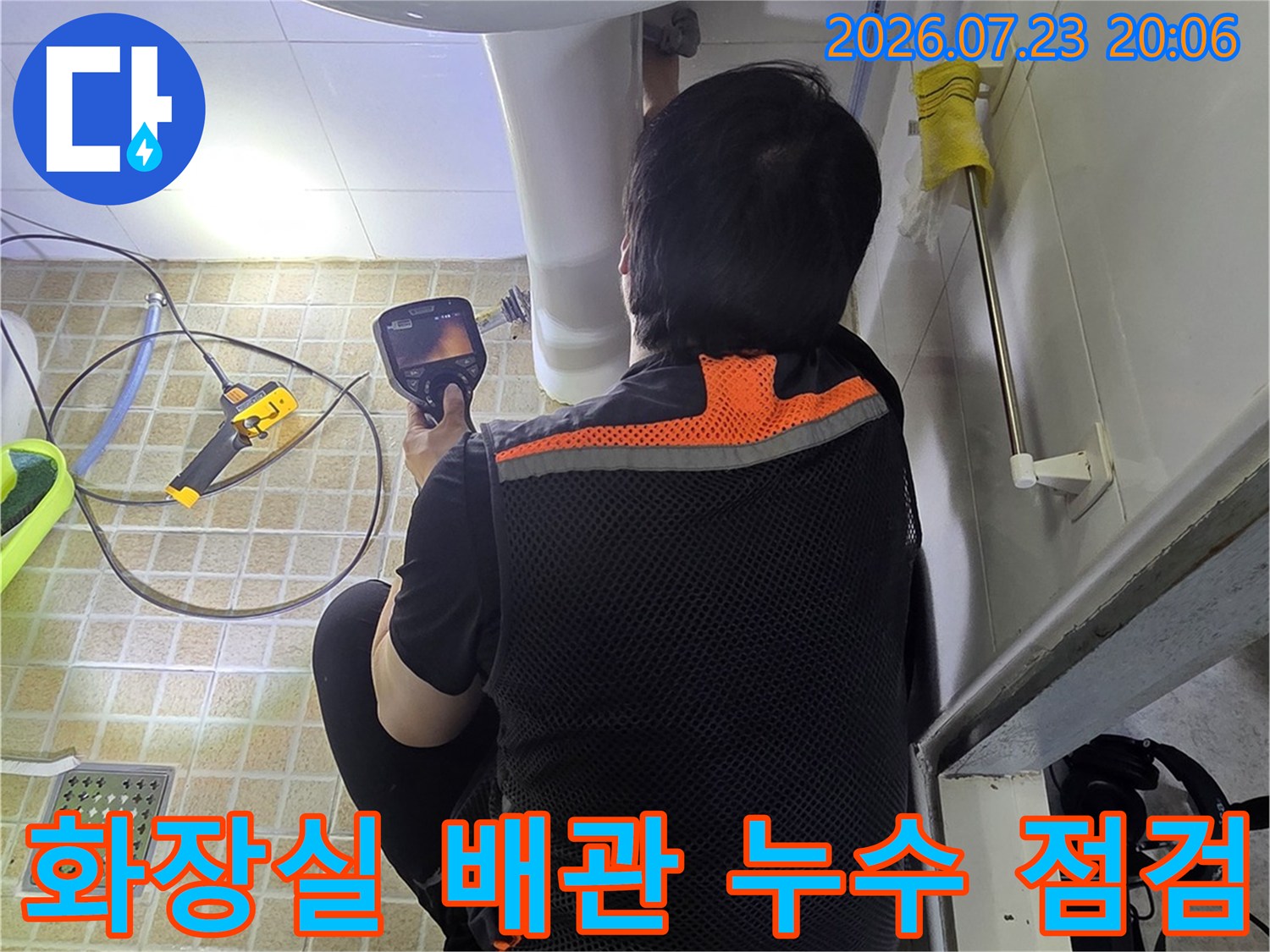 전문가가 세면대 아래쪽 배관 구조를 면밀히 파악하는 장면