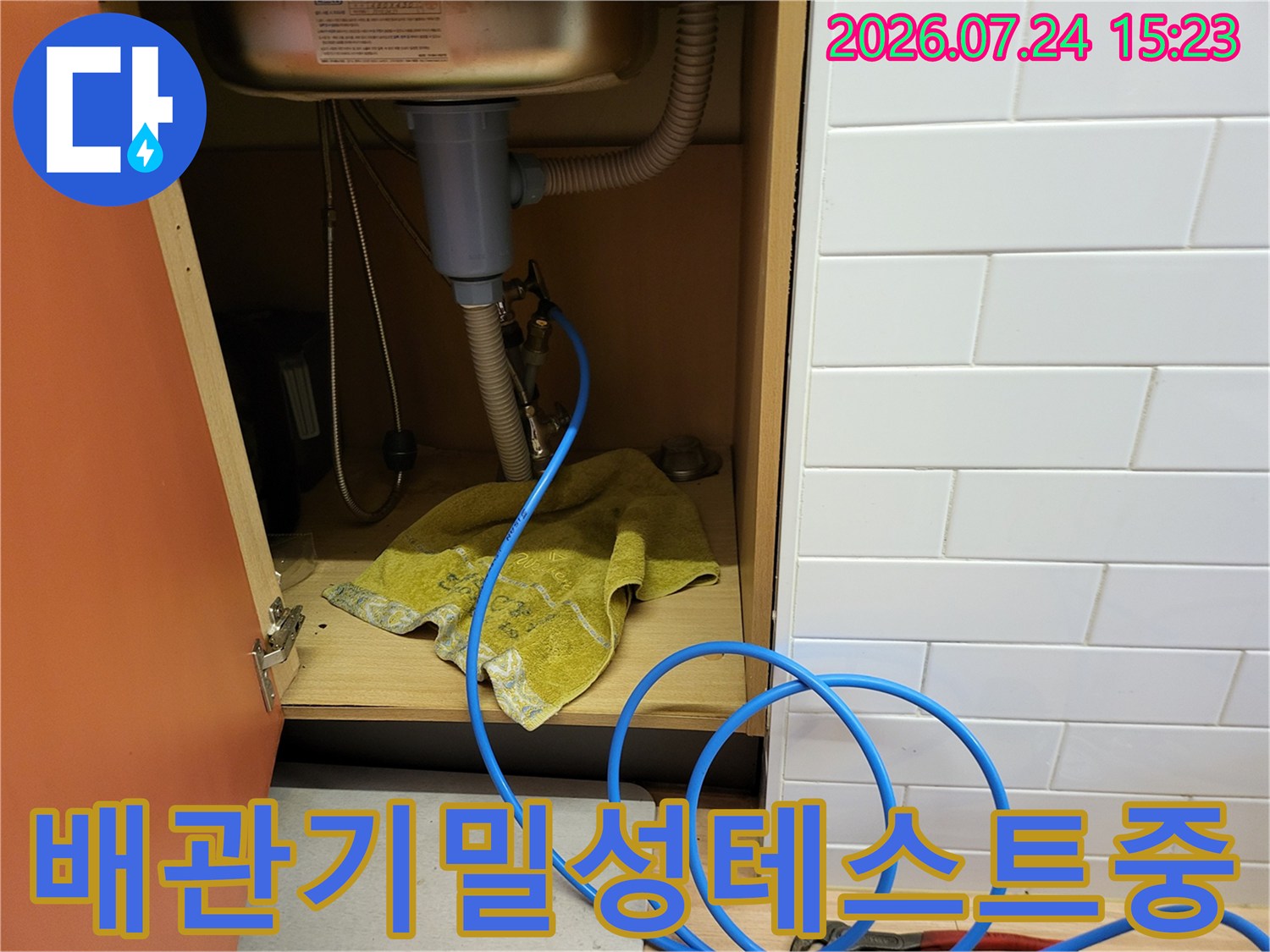 파란색-고무-호스가-싱크대-배수-트랩-부근에-연결되어-누수-압력-검사를-수행하는-사진