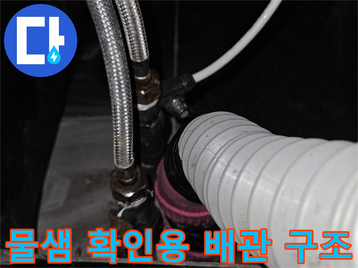 금속 호스와 플라스틱 관이 연결된 수도 배관의 상세 모습