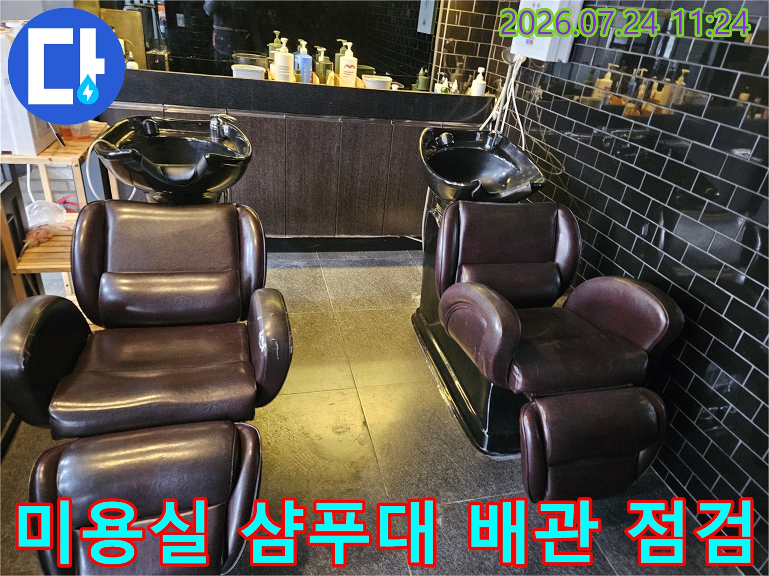 미용실 내부에 배치된 갈색 가죽 소재의 샴푸대와 타일 벽면