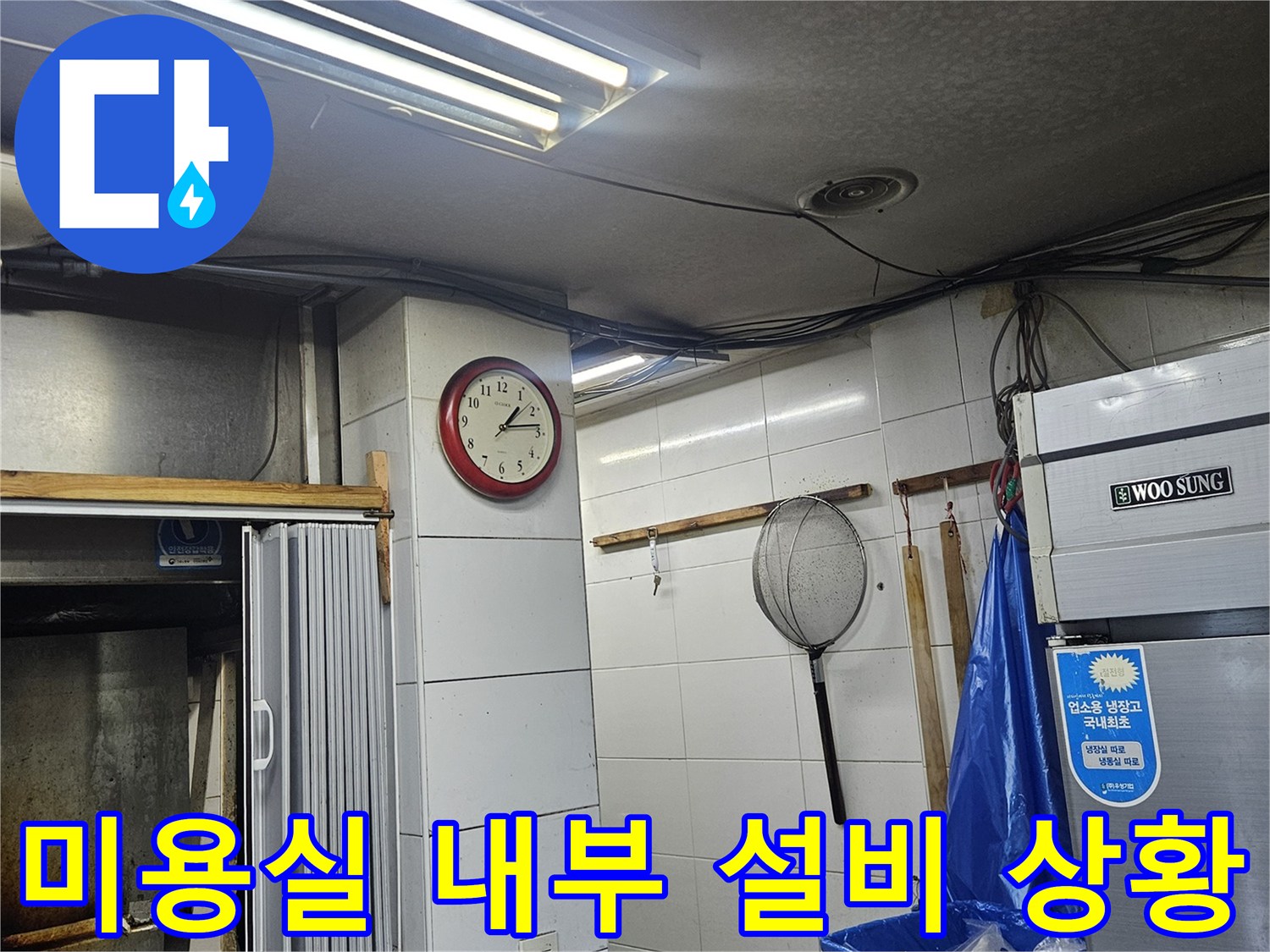 미용실 벽면 타일과 냉장고 주변의 배관 관련 시설물 사진