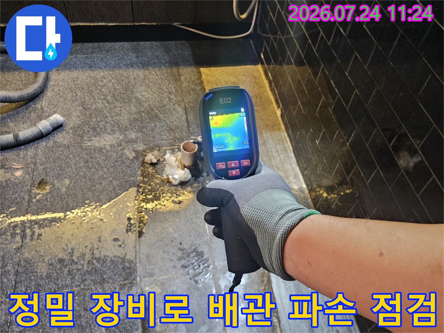 온수 배관이 노출된 부위에서 탐지기를 사용하여 누수 지점을 확정하는 모습