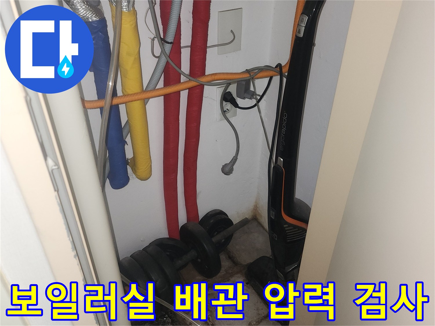 보일러실 내부의 빨간색, 노란색, 파란색 배관에 공압 장비를 연결하여 누수를 점검하는 모습입니다.