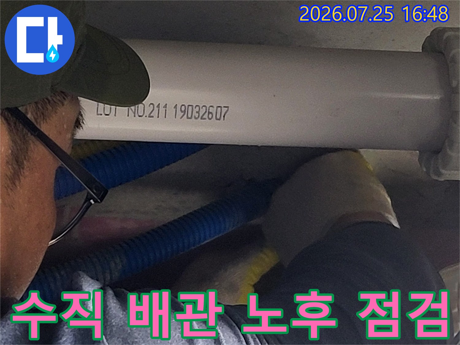 작업자가 수직으로 설치된 흰색 오수 배관을 손으로 확인하며 상태를 파악함