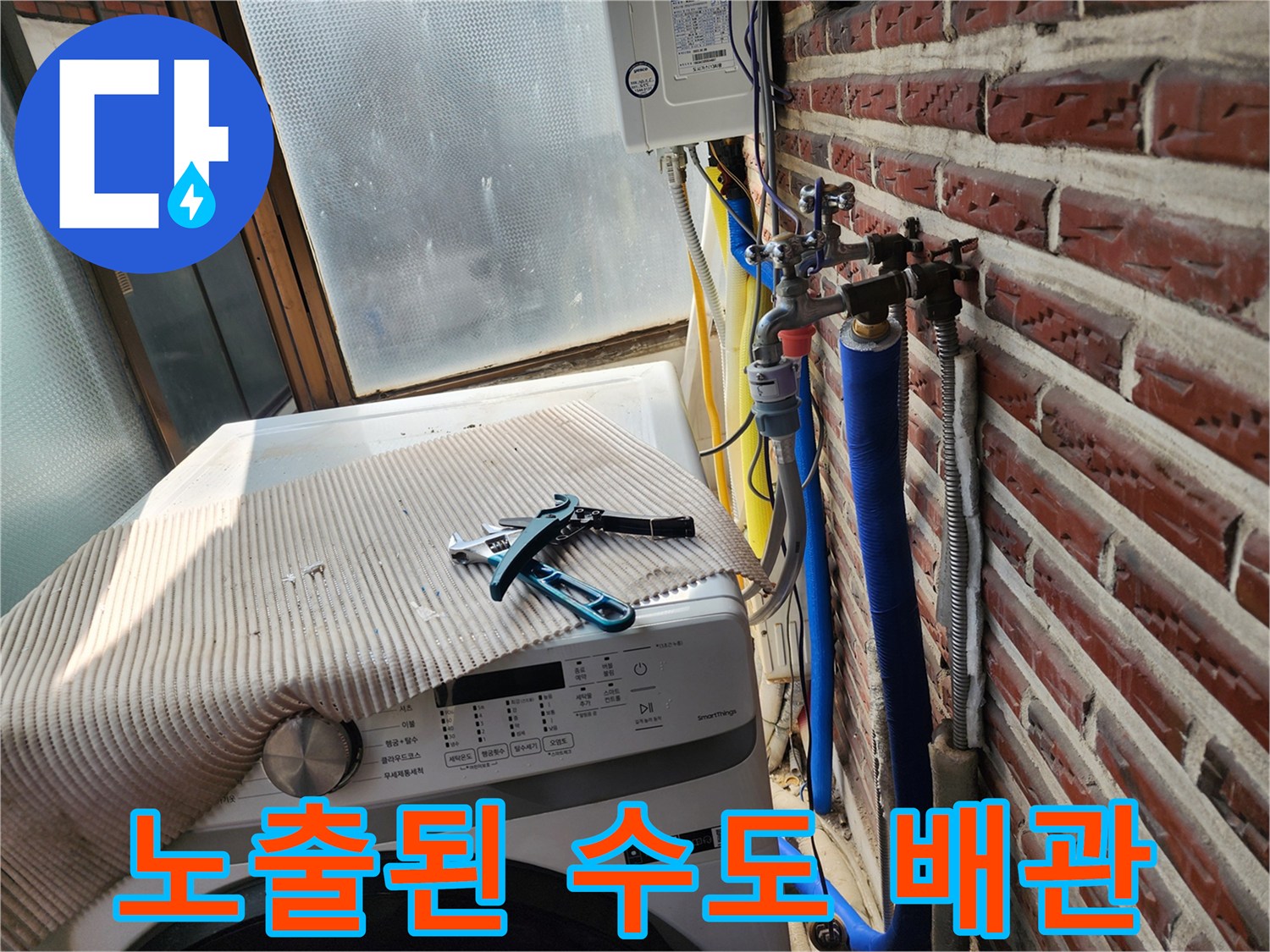 벽돌 벽을 따라 설치된 파란색 보온재와 금속 밸브 연결부
