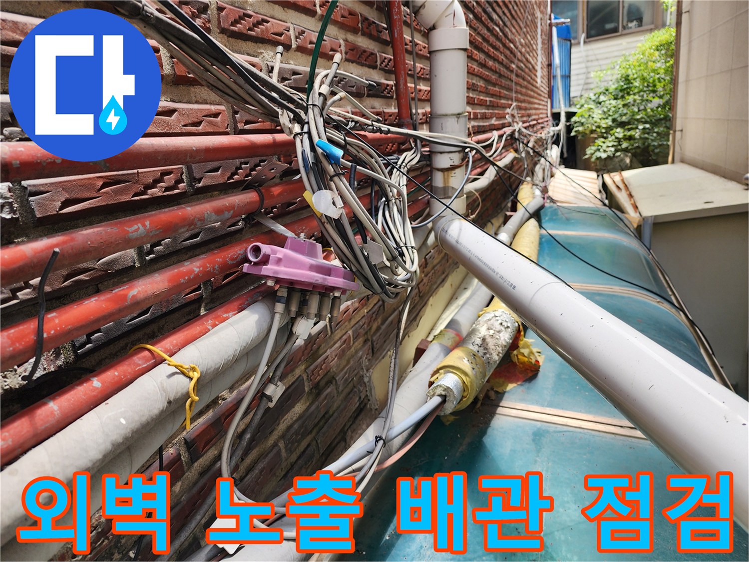 성북구 건물 외벽에 복잡하게 얽힌 수도 및 온수 배관의 상태를 확인하는 모습입니다.