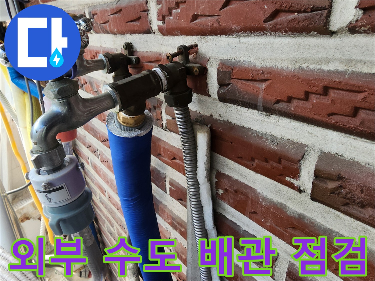 외벽 벽돌 사이로 연결된 노출형 수도 밸브와 배관들