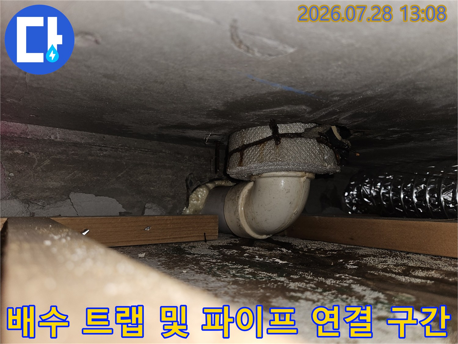 굴곡진 배수관의 꺾임 부위와 바닥 접합부를 촬영한 사진