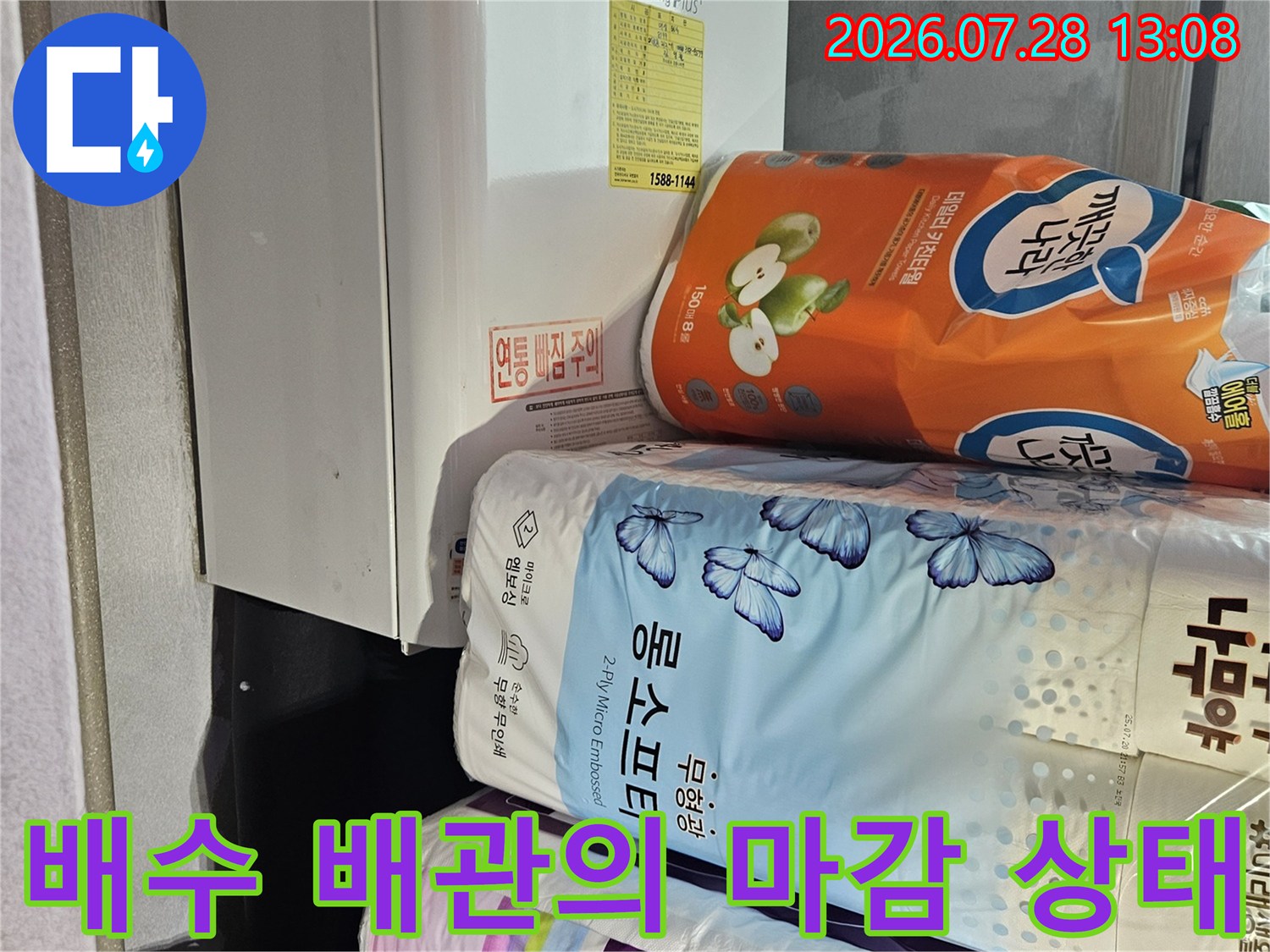 싱크대 아래 공간 내 위치한 다양한 주방 관련 물품과 배수관