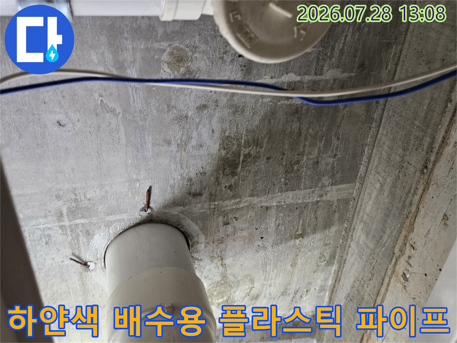 싱크대 하부 공간에서 시공된 흰색 배수 파이프의 연결 마찰 부위를 확인하는 사진
