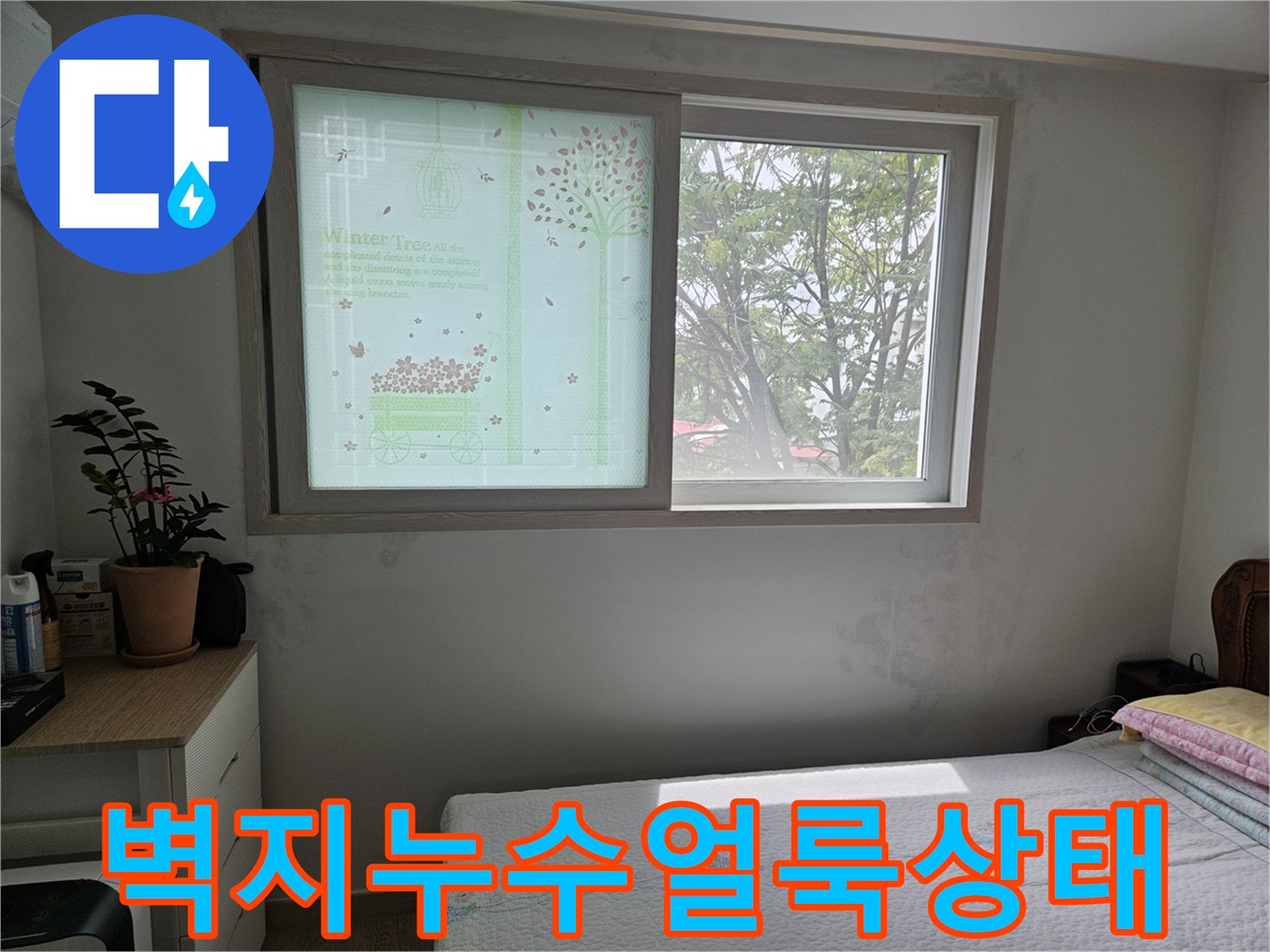 창문 아래쪽 벽지에 번진 누수 흔적과 변색된 부위