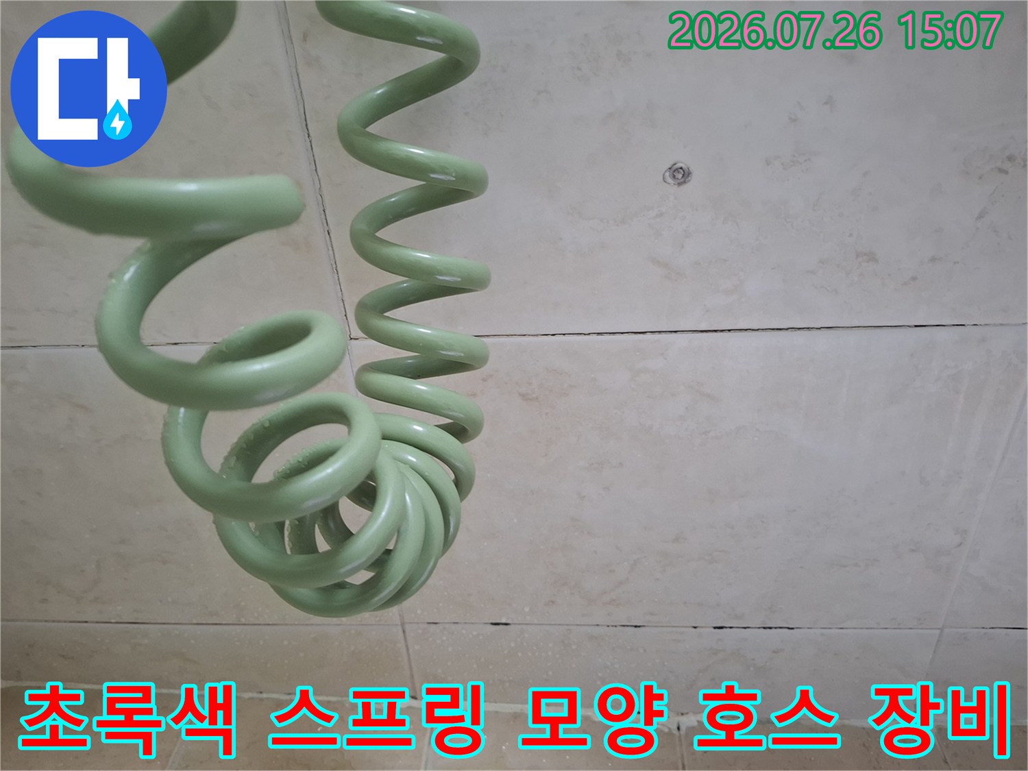 누수 탐지를 위해 사용되는-초록색의-나선형-전선-호스가-벽면-앞에-위치한-모습