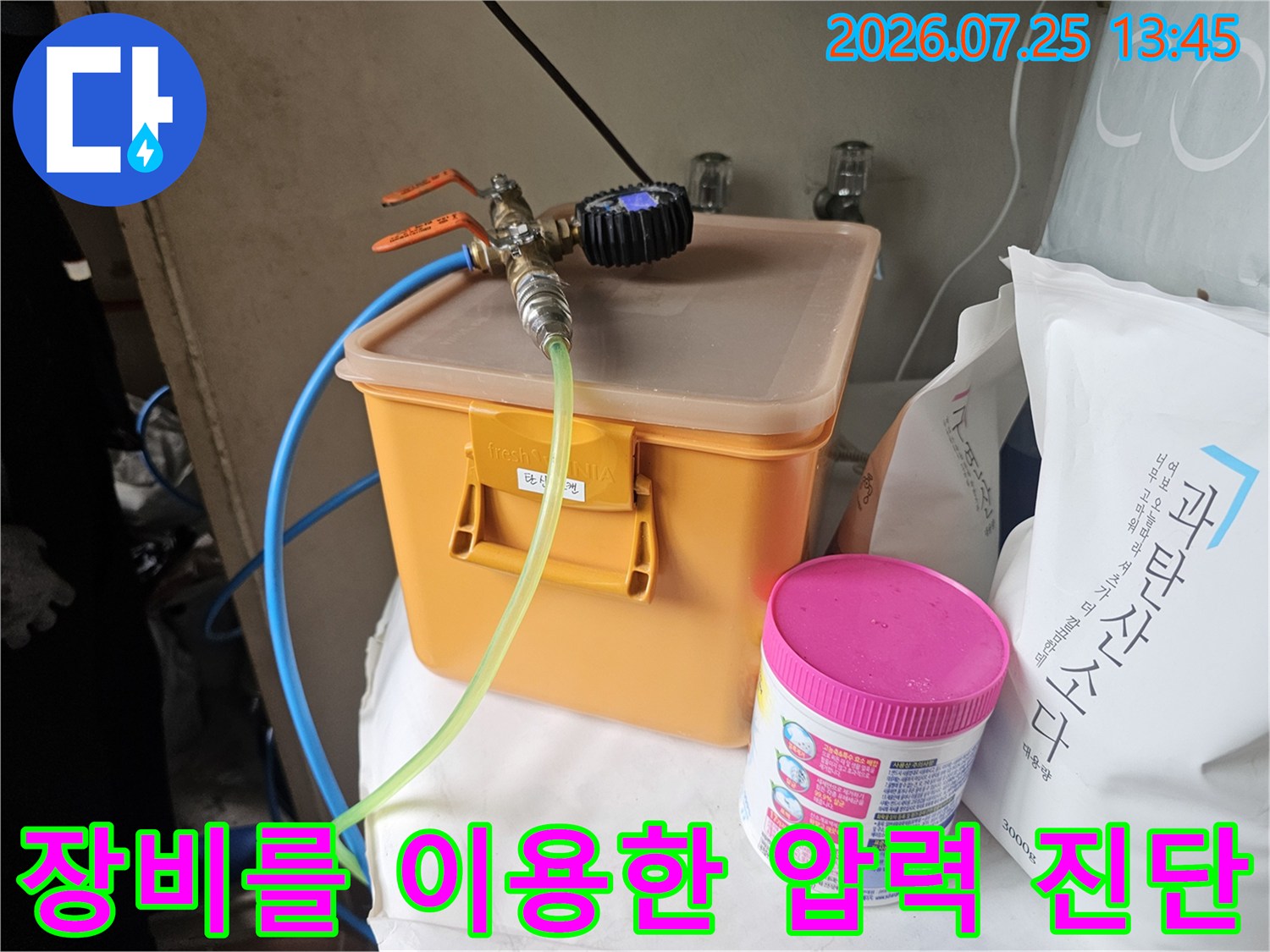 노란색 수납함 위에 설치된 공기압 테스트 장비와 투명 호스