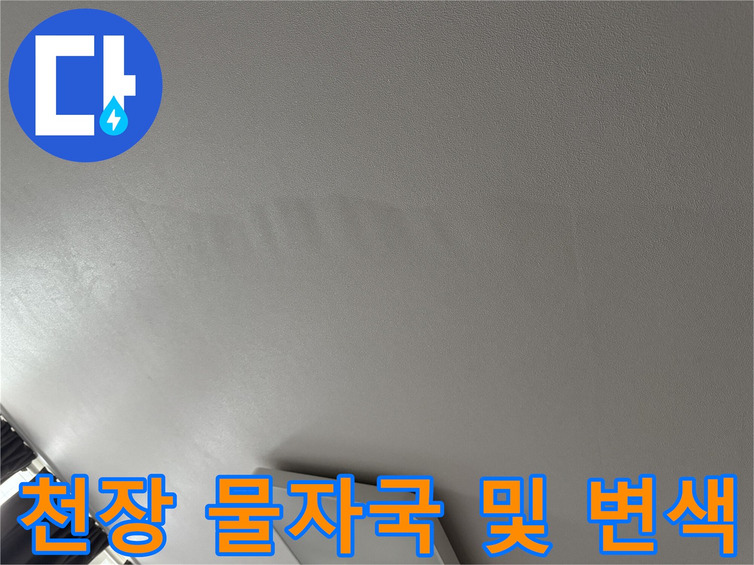 누수로 인해 어둡게 얼룩진 천장 도배지