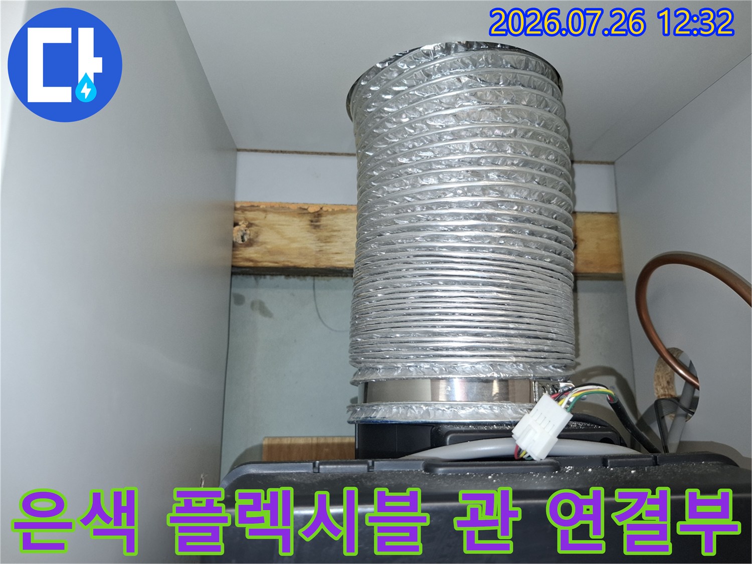 천장 슬라브 근처에 설치된 은색의 주름진 배관과 전선 뭉치들