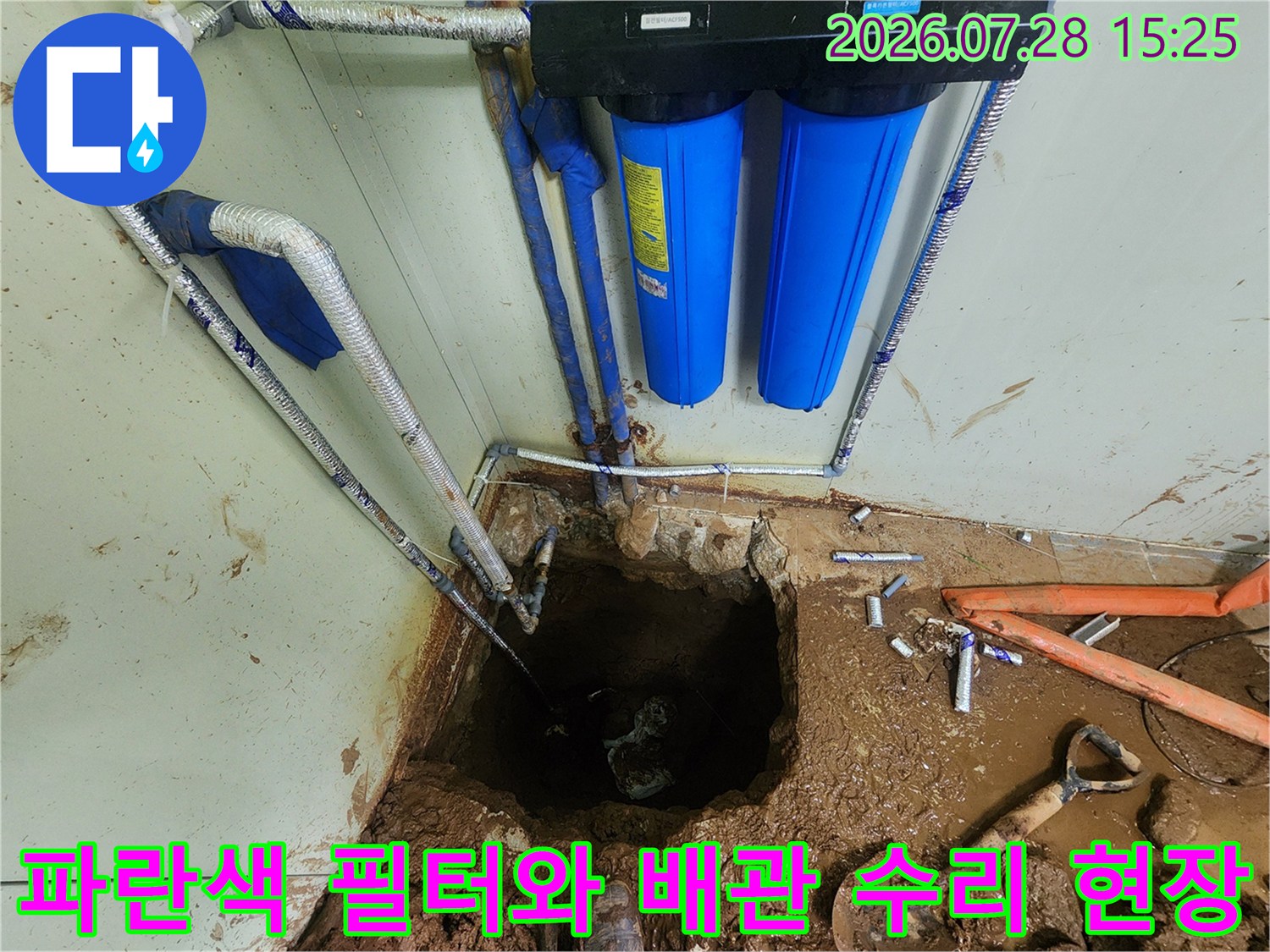 수리 대기 중인 파란색 여과 장치와 굴착된 토사 사이의 배관