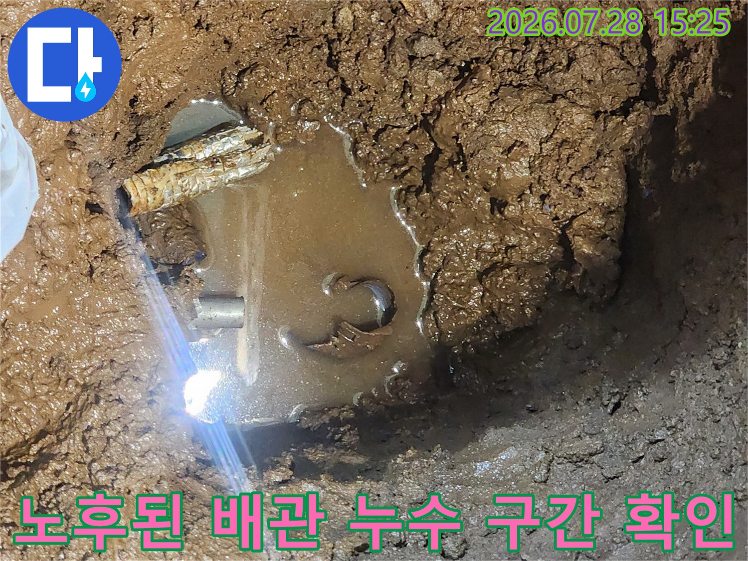 진흙 속에서 발견된 노후 배관과 고인 물의 현장 모습