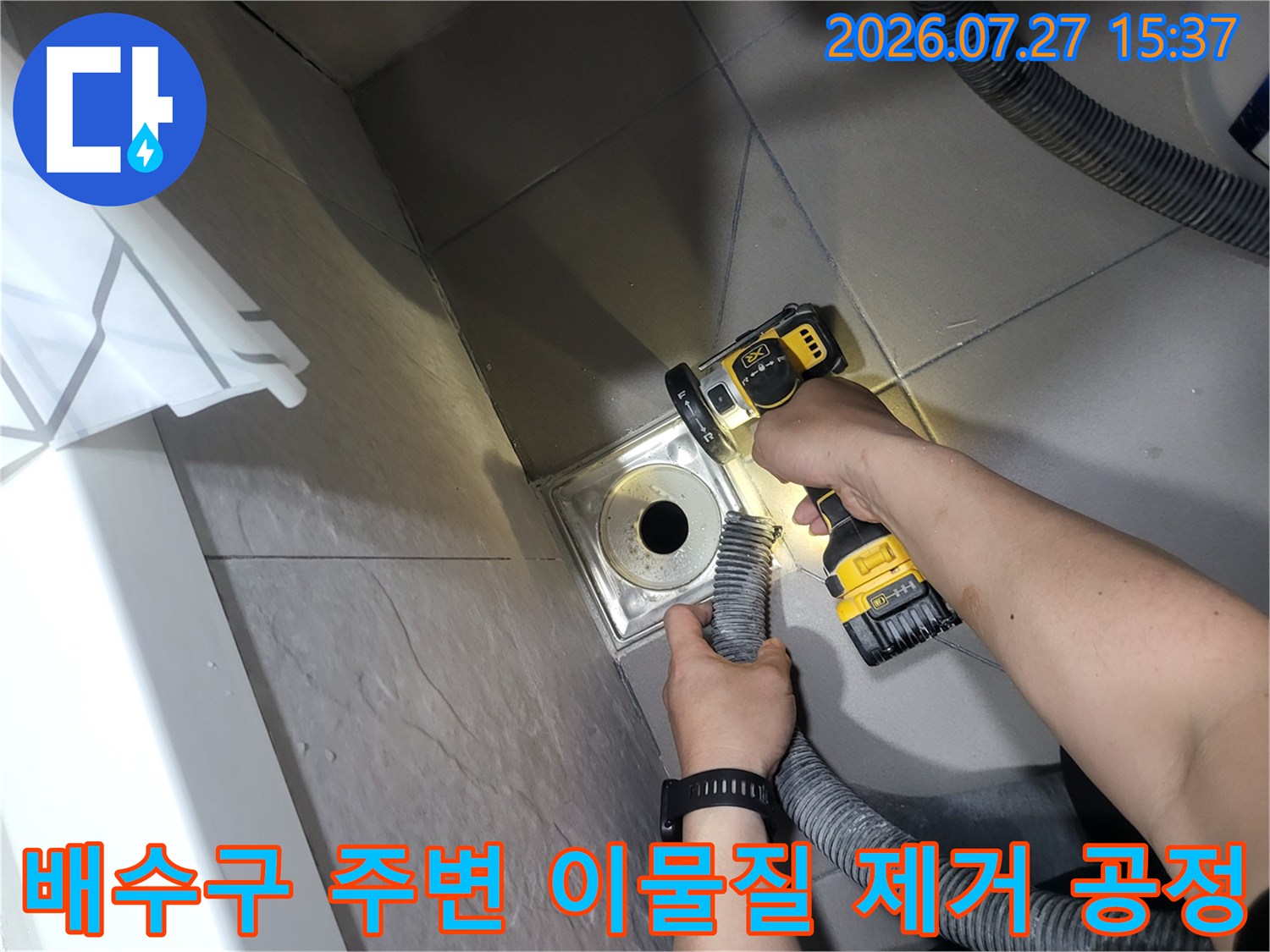 밝은 조명 아래서-전동 브러쉬로 화장실 배수구 유가 틈새를 세척하고 있는 엔지니어의 손