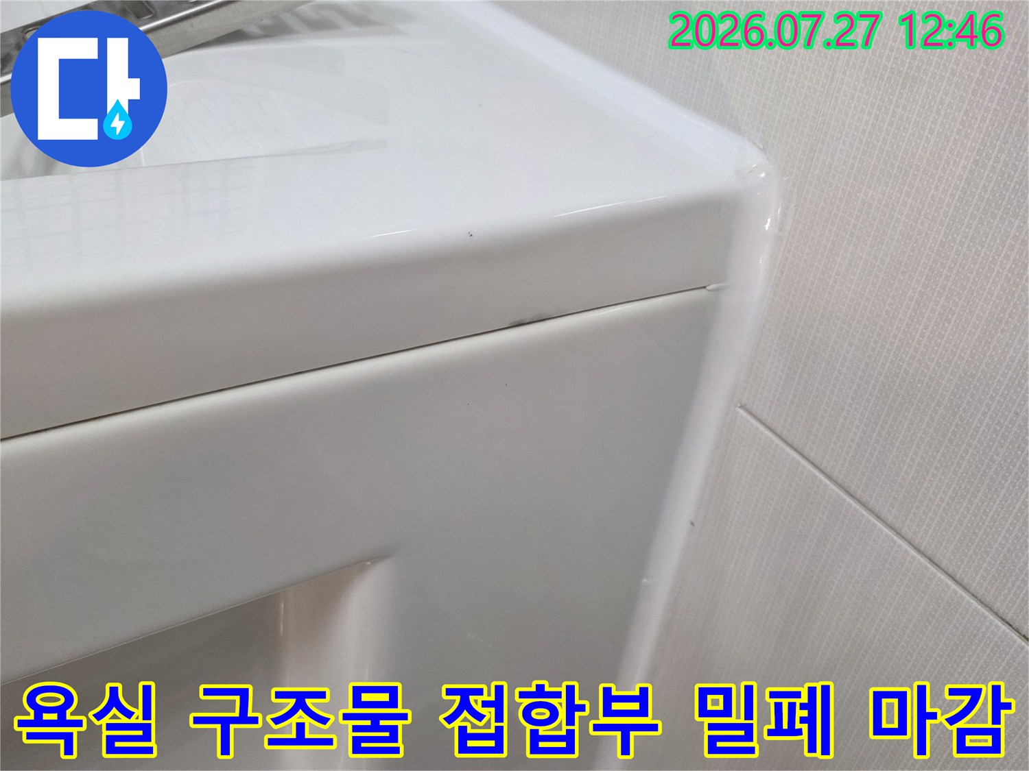 벽면 타일과 욕실 가구가 만나는 수직 경계면에 시공된 화이트 실리콘-마무리