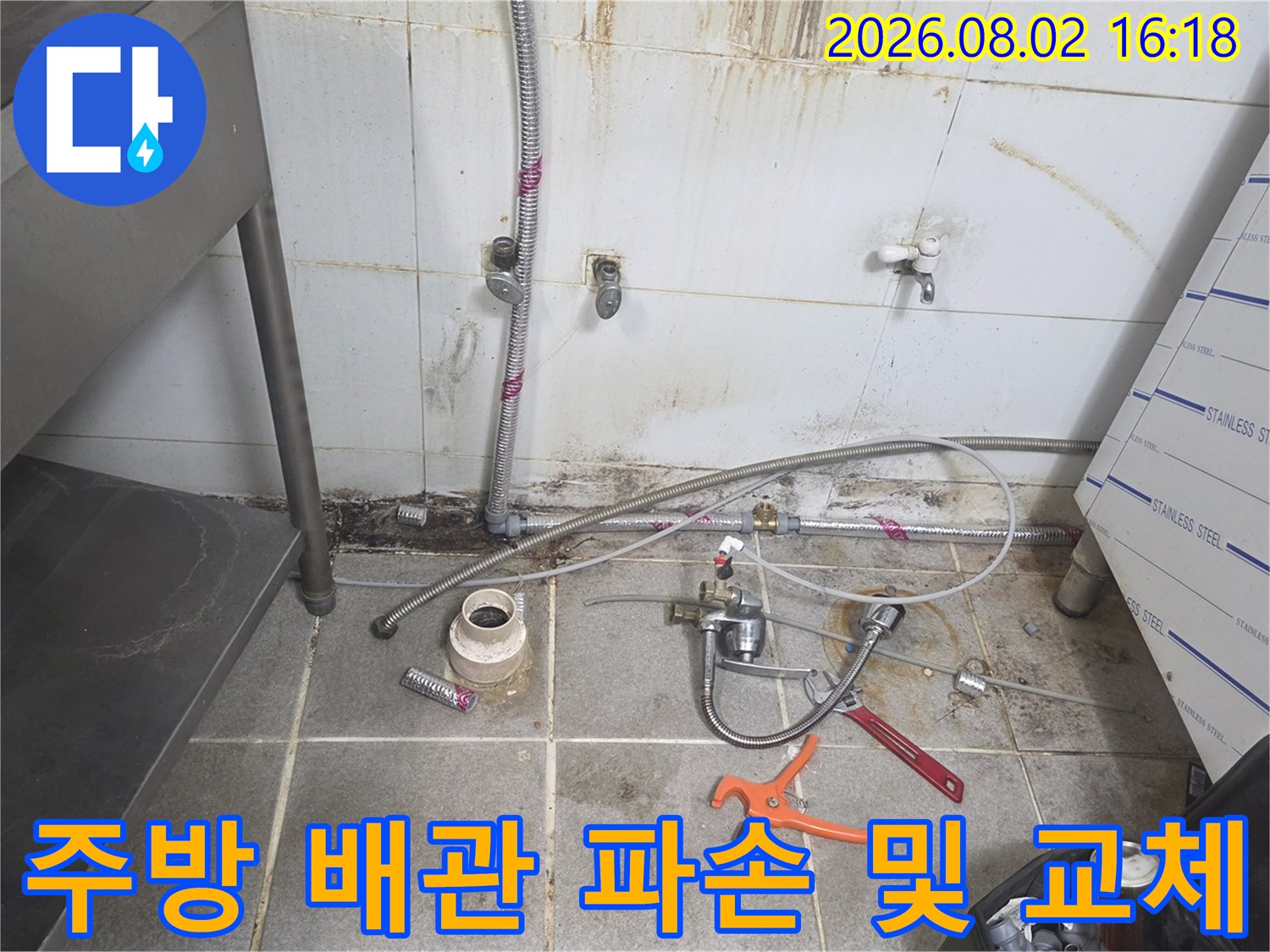 노출된 주방 배관과 수동 공구가 배치된 점검 구역