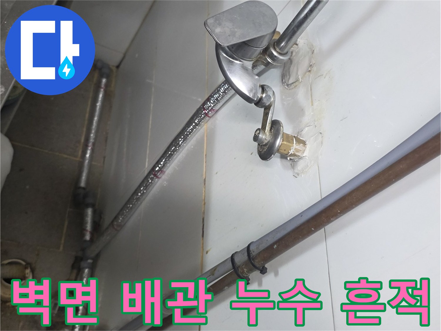 배관 연결부 주변의 습기와 물자국이 남은 타일 벽면