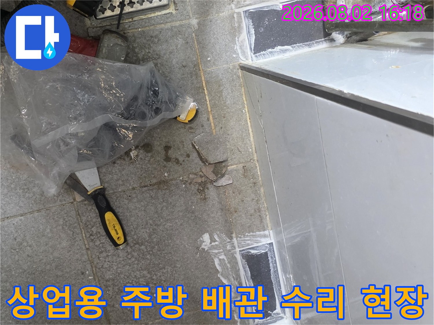 상업용 주방 트렌치 근처 노출된 배관 보수 작업 모습
