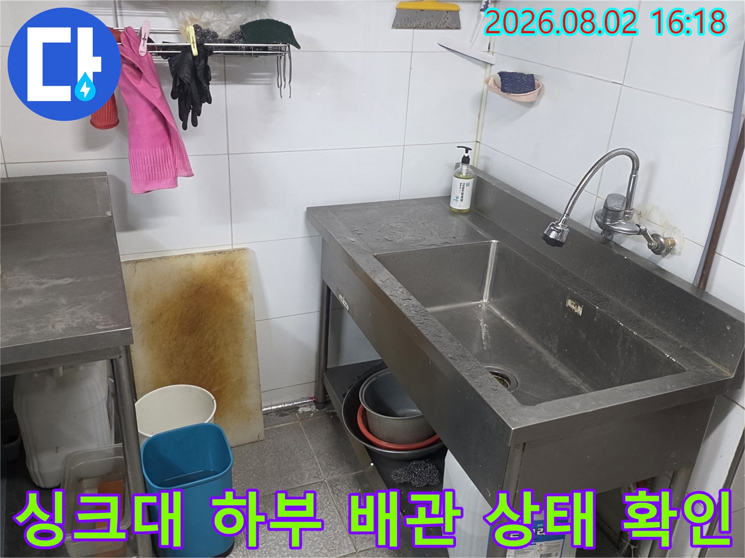 스테인리스 싱크대가 설치된 주방 내부의 배관과 주변 타일