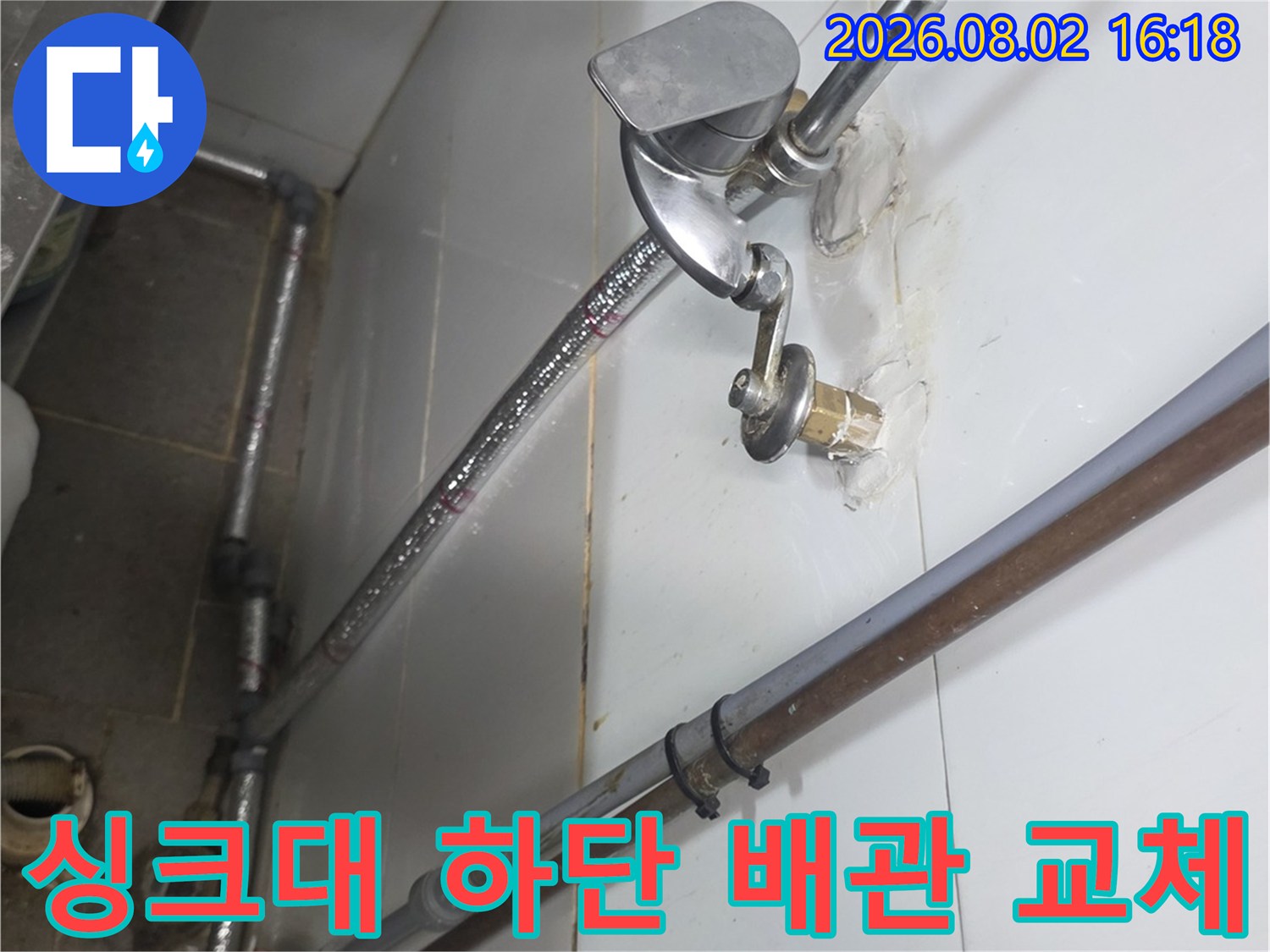 싱크대 아래쪽 노출된 배관과 연결 부위를 수리하는 현장 모습