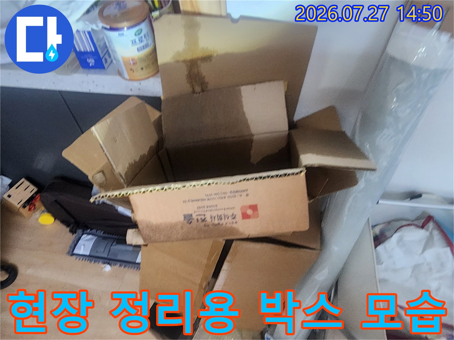 누수 점검 현장에서 사용된 자재와 도구들이 담긴 갈색 종이 상자-모습