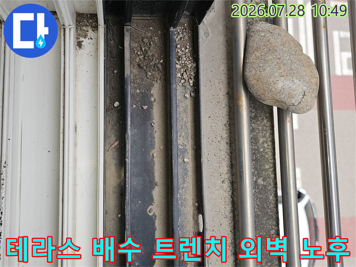 노출된 배수 트렌치와 주변 마감재의 박락 상태를 촬영한 모습