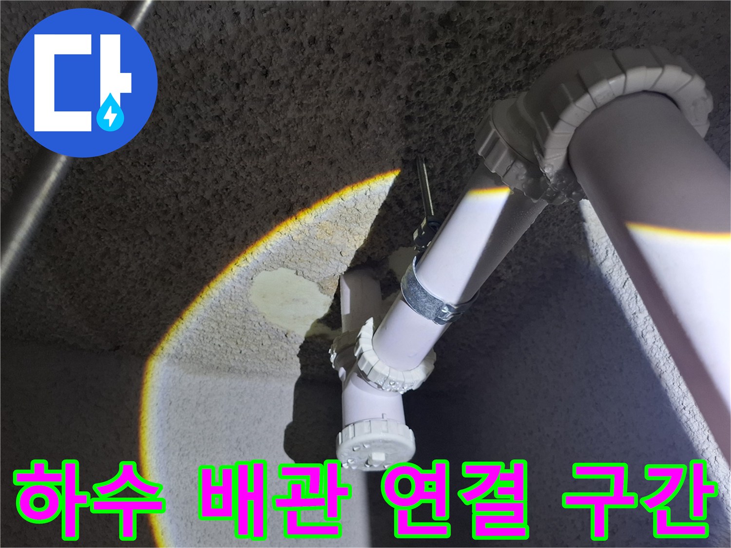 천장에 설치된 흰색 PVC 배관의 굴곡진 엘보 부속 모습