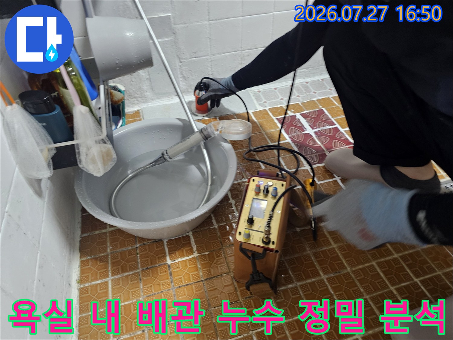 작업자가 장비를 조작하며 화장실 배관의 압력을 체크하는 모습-전문 탐지 과정