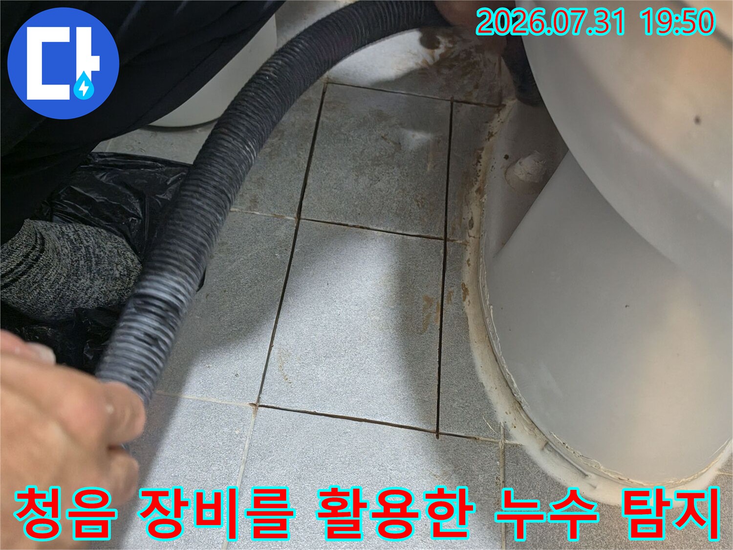 누수 지점을 찾기 위해 청음 탐지기를 배관에 대고 점검하는 장면