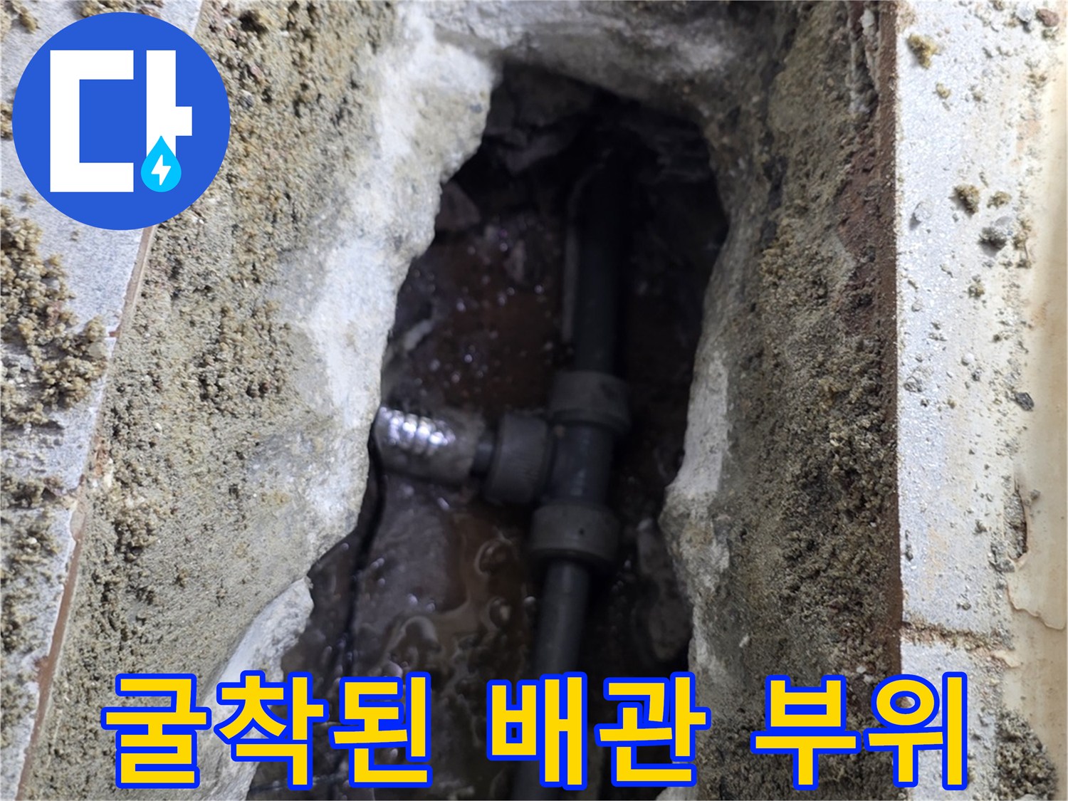 물에 젖은 흙과 함께 드러난 파손된 배관 연결 구간