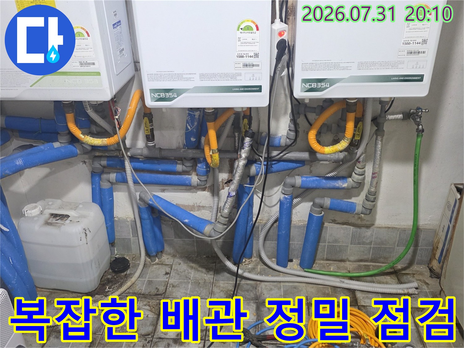 여러 개의 온수기 아래로 연결된 파란색 보온재 및 각종 배관이 얽혀 있는 설비 현장